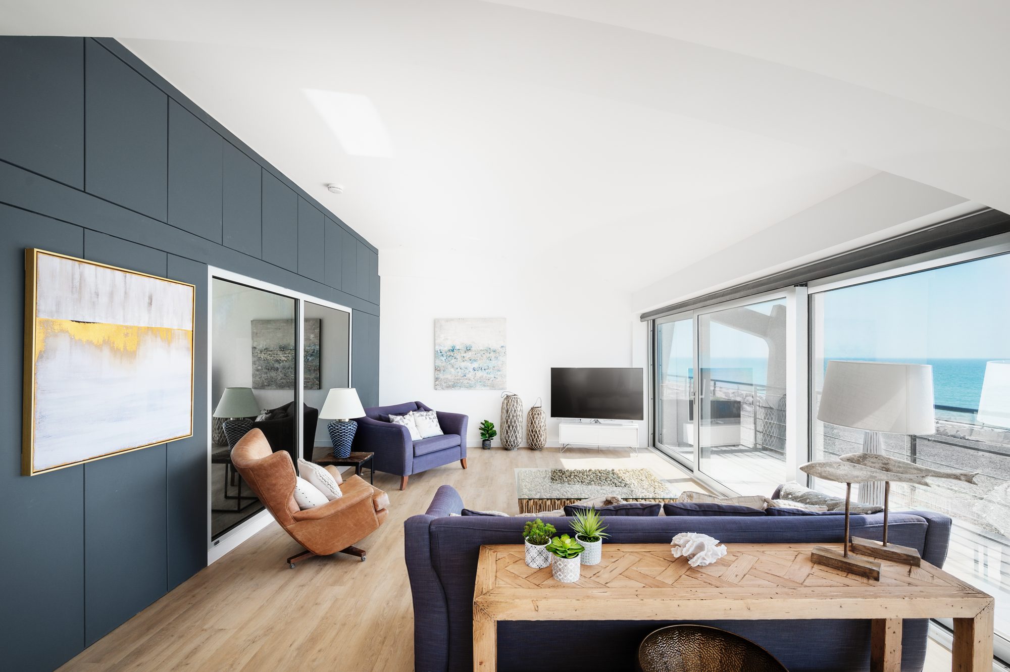 The open-plan living space at Alexanders, with the sea beyond the balcony